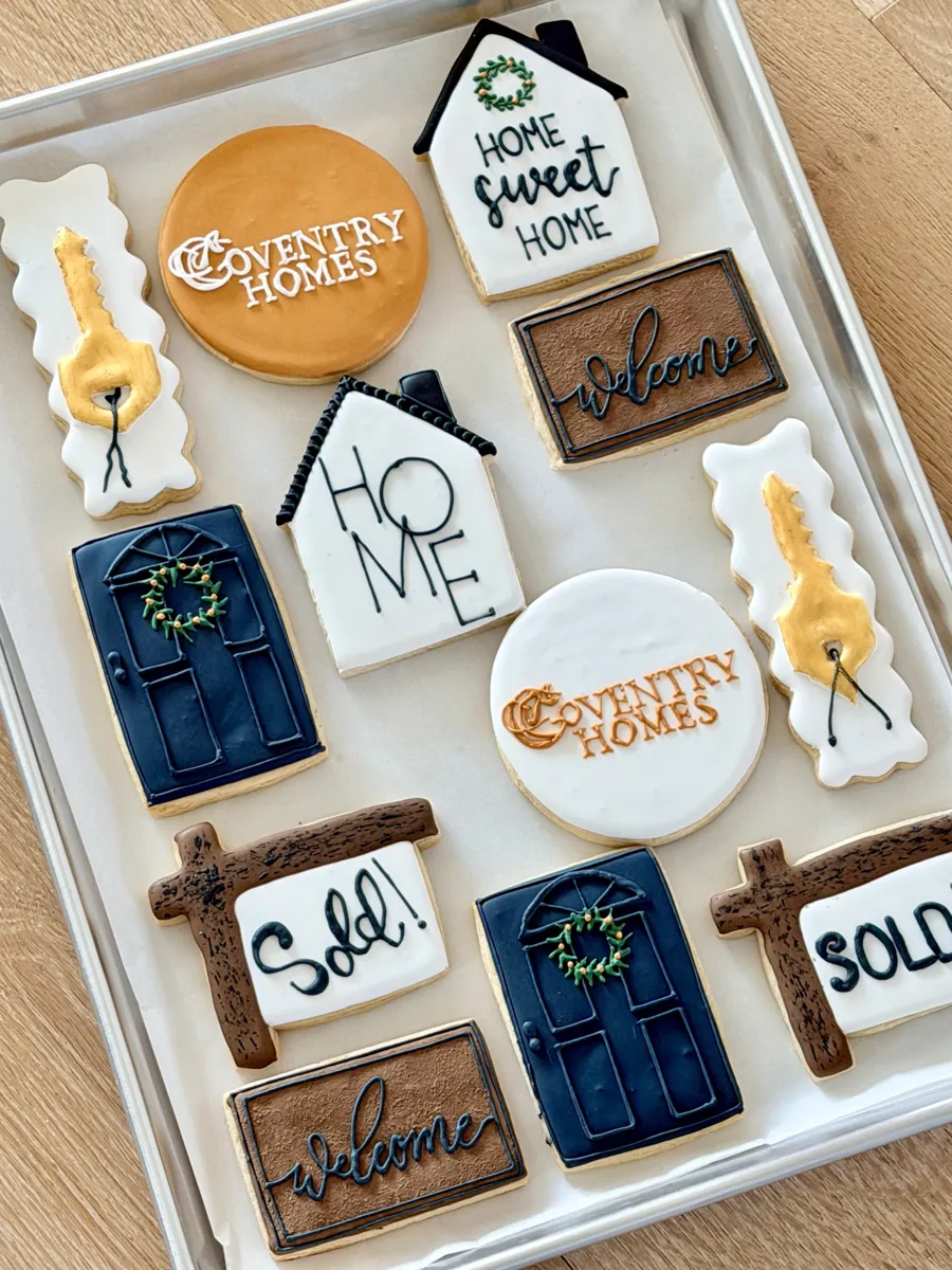 Custom logo cookies for a home builder with company logo, Sold sign, gold keys, front doors and welcome mat