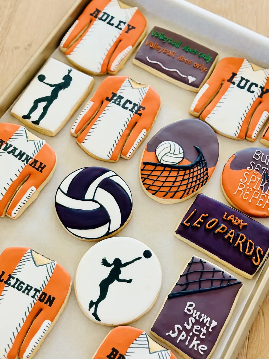 Volleyball team cookies with personalized orange jerseys, volleyball, net and player silhouettes